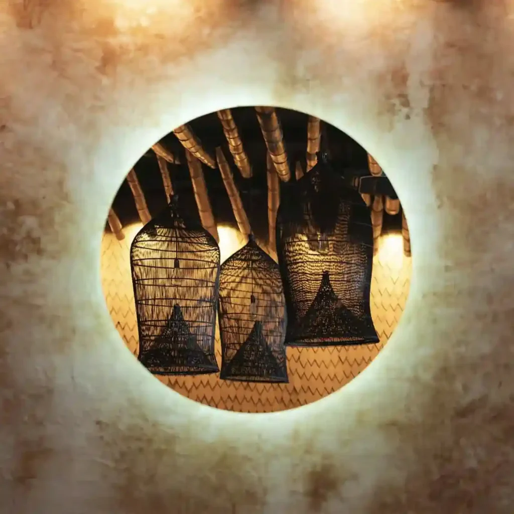 backlit circular mirror reflecting handcrafted rattan lanterns at Billy Ho modern Japanese restaurant in Canggu